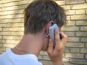 Een jongen met zijn mobieltje in de weer