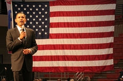 Barack Obama spreekt met op de achtergrond de Amerikaanse vlag