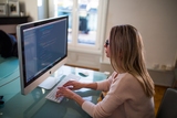 een volwassen vrouw programmeert op de Mac