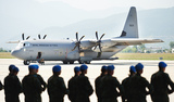 Militairen met op de achtergrond een transportvliegtuig van het leger