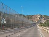Een lang hek bij de grensovergang tussen Spanje en Marokko