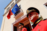 bewakers met vlaggen van Albanie en de Europese Unie