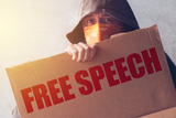 Een man met een bord in zijn handen met de tekst "FREE SPEECHT"